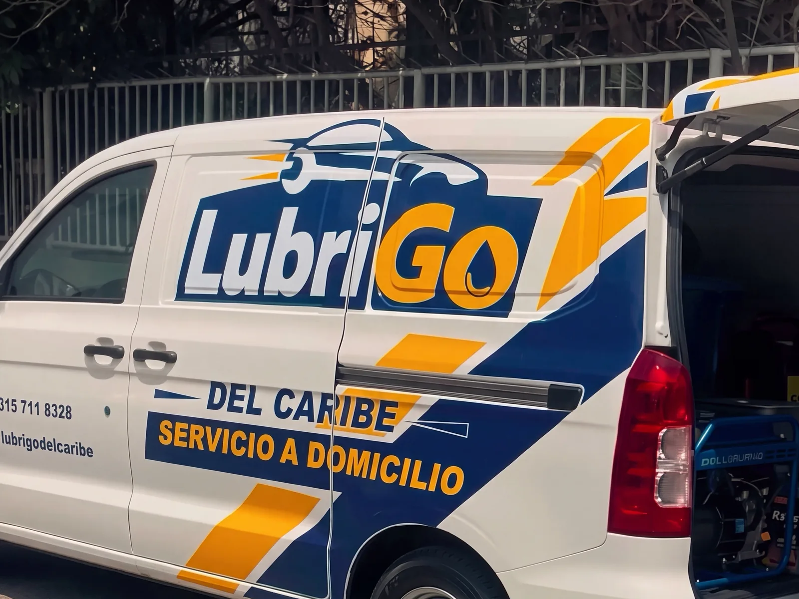 Camioneta de LubriGo Del Caribe con la puerta trasera abierta y el equipo a bordo