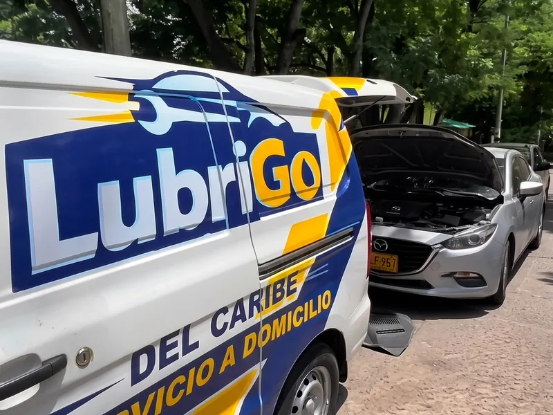 La camioneta de LubriGo llegando a atender un carro en una calle arbolada de Cartagena