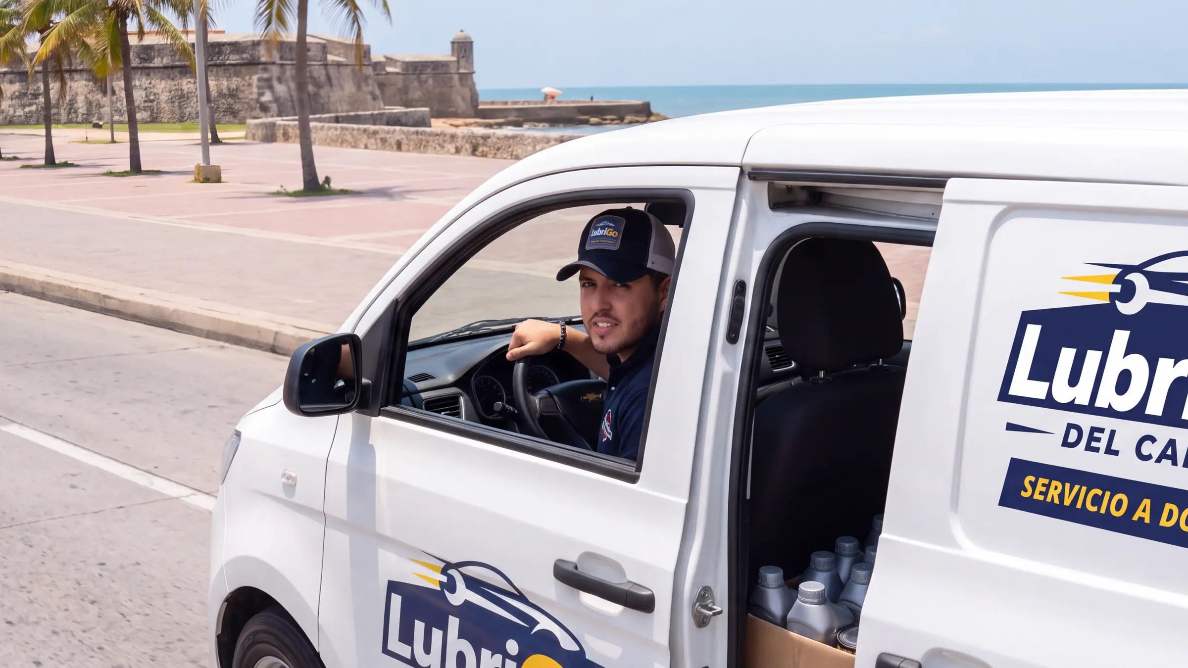 Camioneta de LubriGo Del Caribe en ruta por el malecón de Cartagena, cargada con aceites y filtros