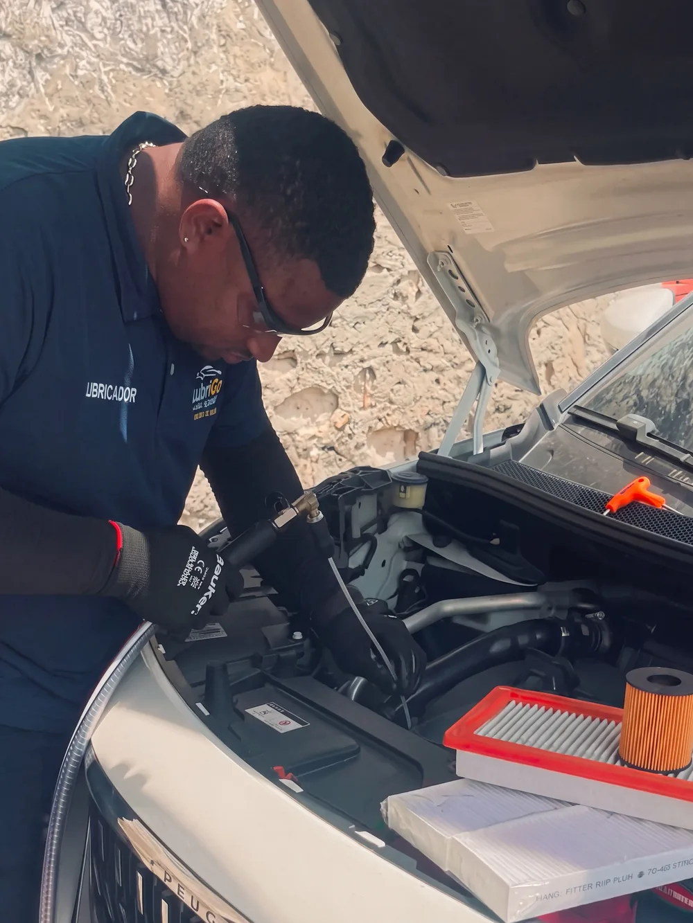 Técnico de LubriGo con el aceite y los filtros del servicio